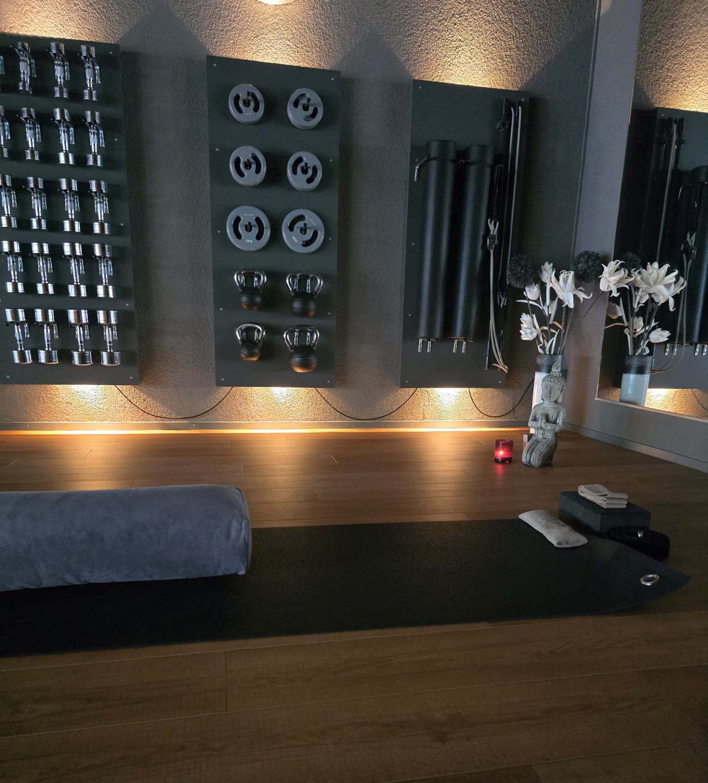 Gerätewand im Studio mit Hanteln, Gewichtsscheiben, Kettlebells und Faszienrollen
